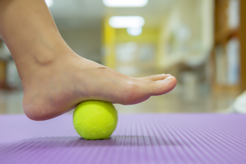 Đặt một quả bóng tennis/ bóng massage trên một khối trụ cao hơn sàn nhà